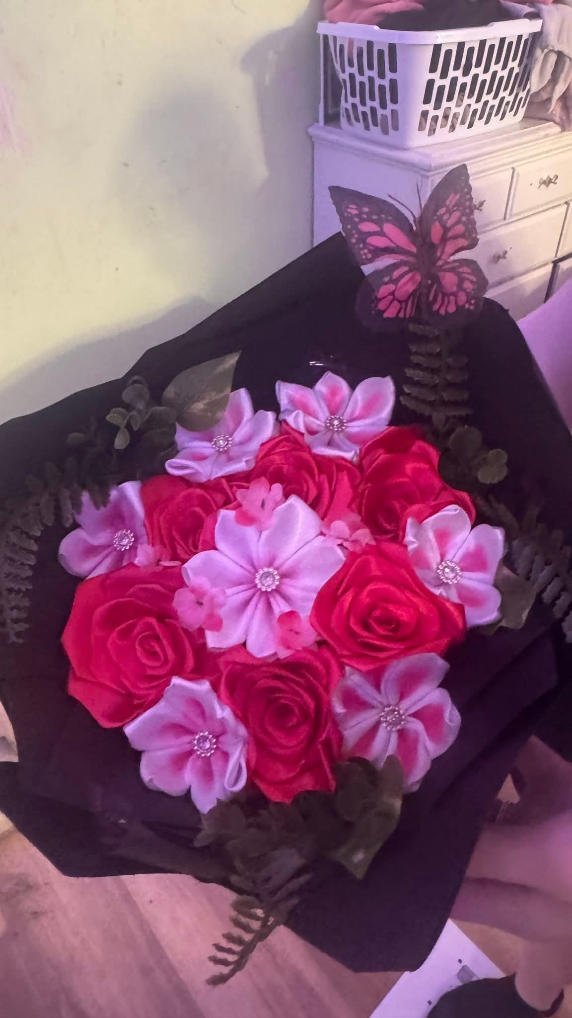 Red ribbon rose bouquet with pink accent flowers and a painted monarch butterfly