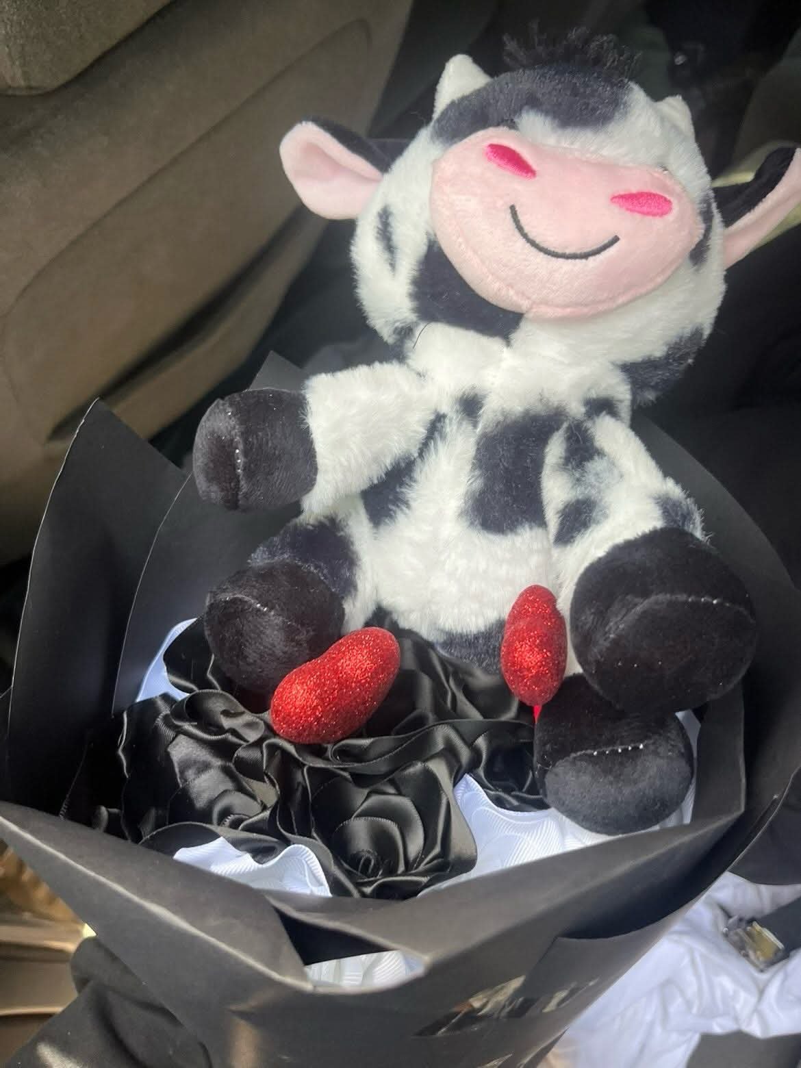 Black and white ribbon rose bouquet with a cow plush and glitter heart accents