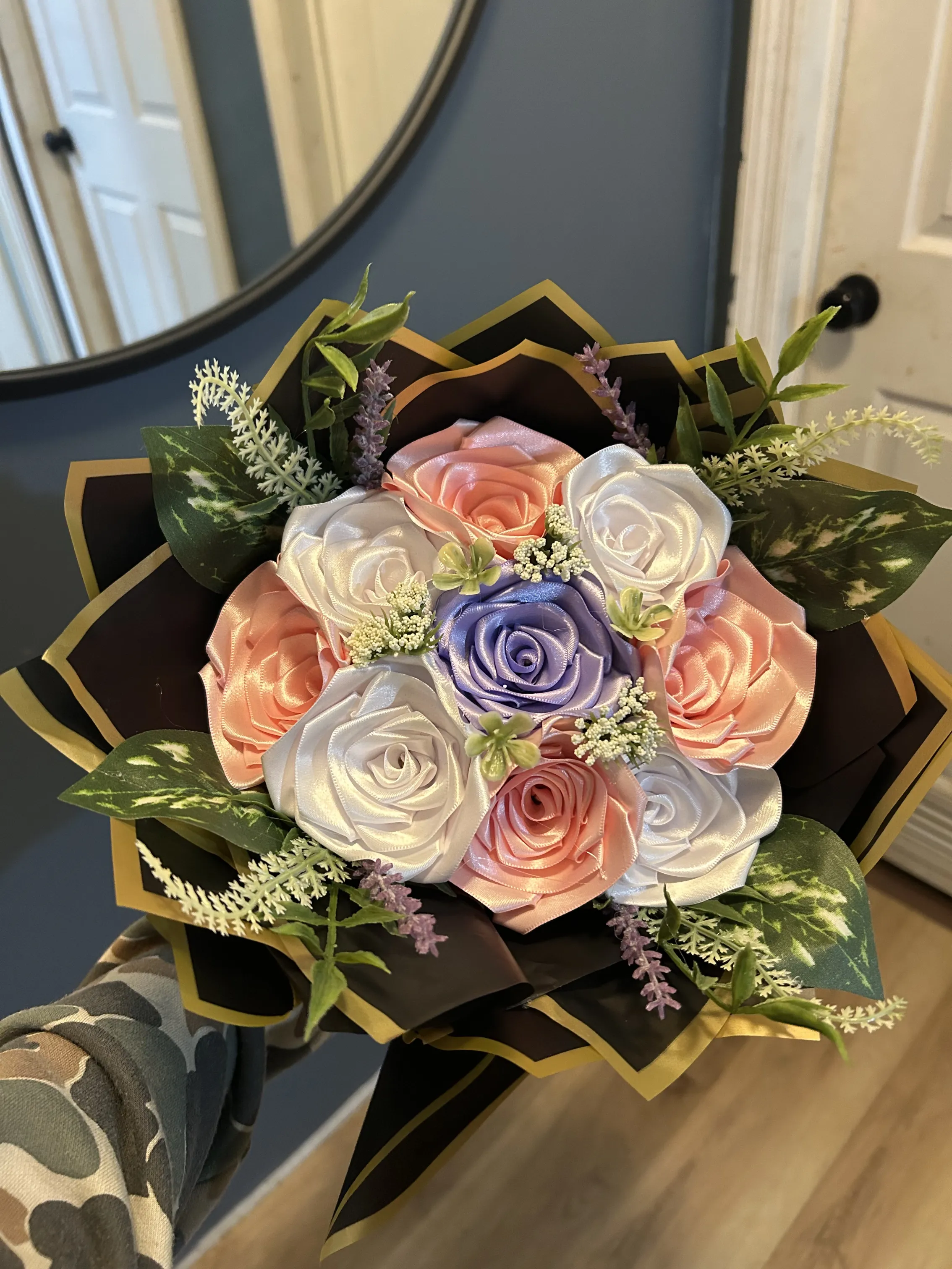 Peach, white and lavender ribbon rose bouquet with greenery in a black and gold wrap