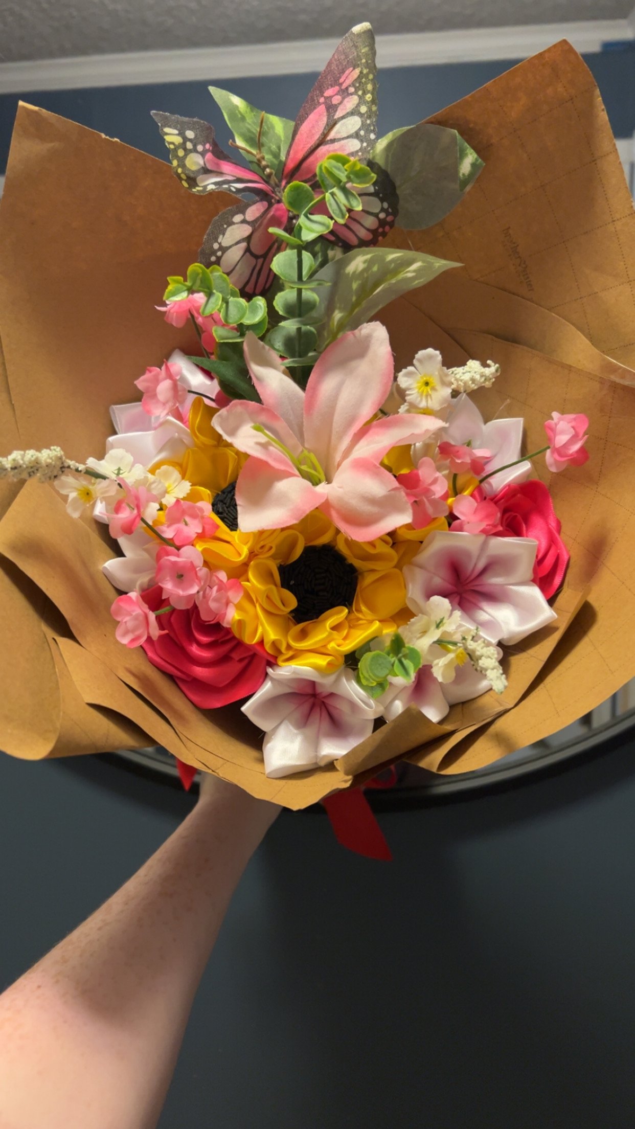 Handmade ribbon bouquet with sunflowers, roses, a pink lily, and a monarch butterfly accent